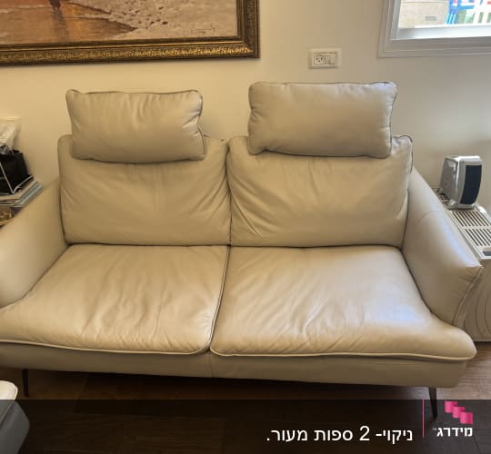 ספה לבנה בחדר עם חפצים מסביב